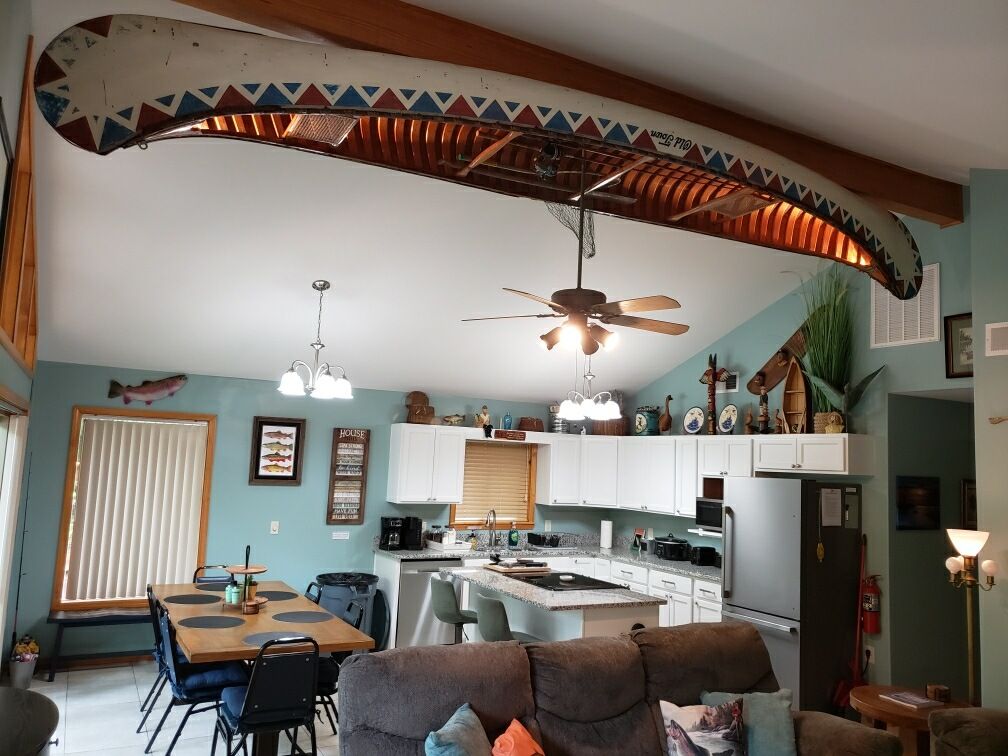 Open living and kitchen space beneath the antique canoe